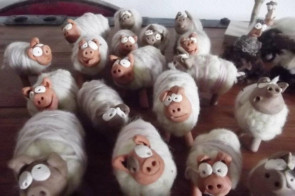 A flock of small sheep figures with clay heads and bodies of white wool