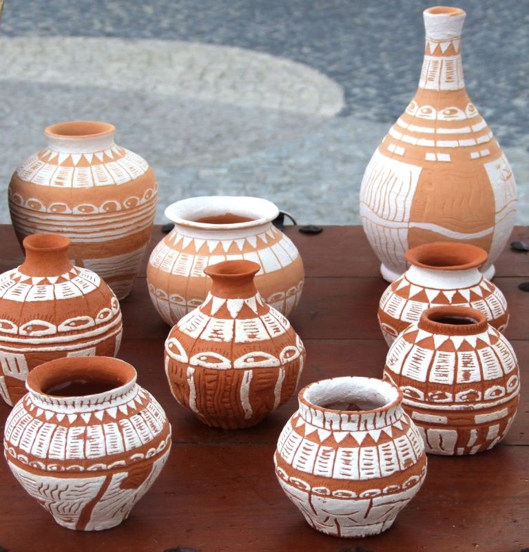 Group of terracotta vases decorated with white scratched patterns of lines and triangles
